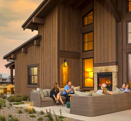 guests getting cozy outside next to a fireplace on their cabin veranda